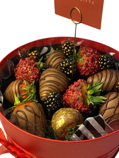 Chocolates in a red box with a card on a white background luxury chocolate-covered strawberries with gold leaf Zürich